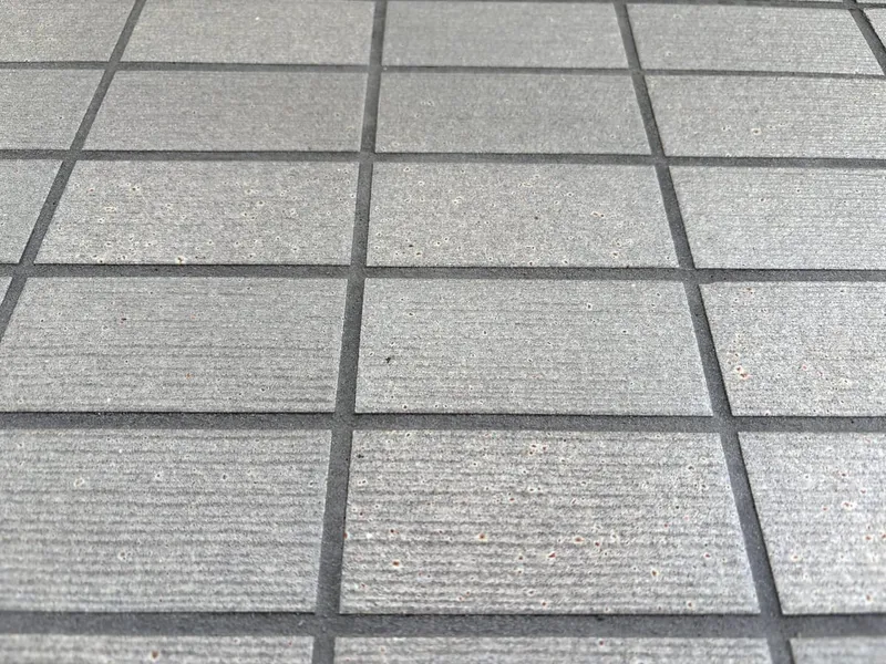 整ったグリッドで張られた白系タイル壁面